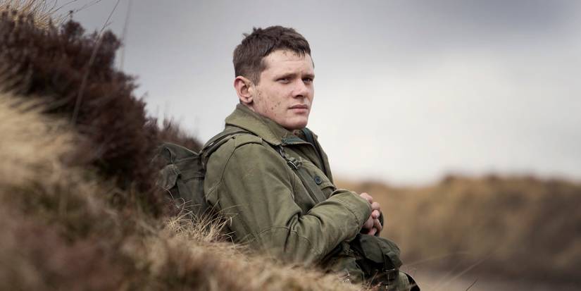 Jack O'Connell as Gary Hook resting on the side of a hill in '71