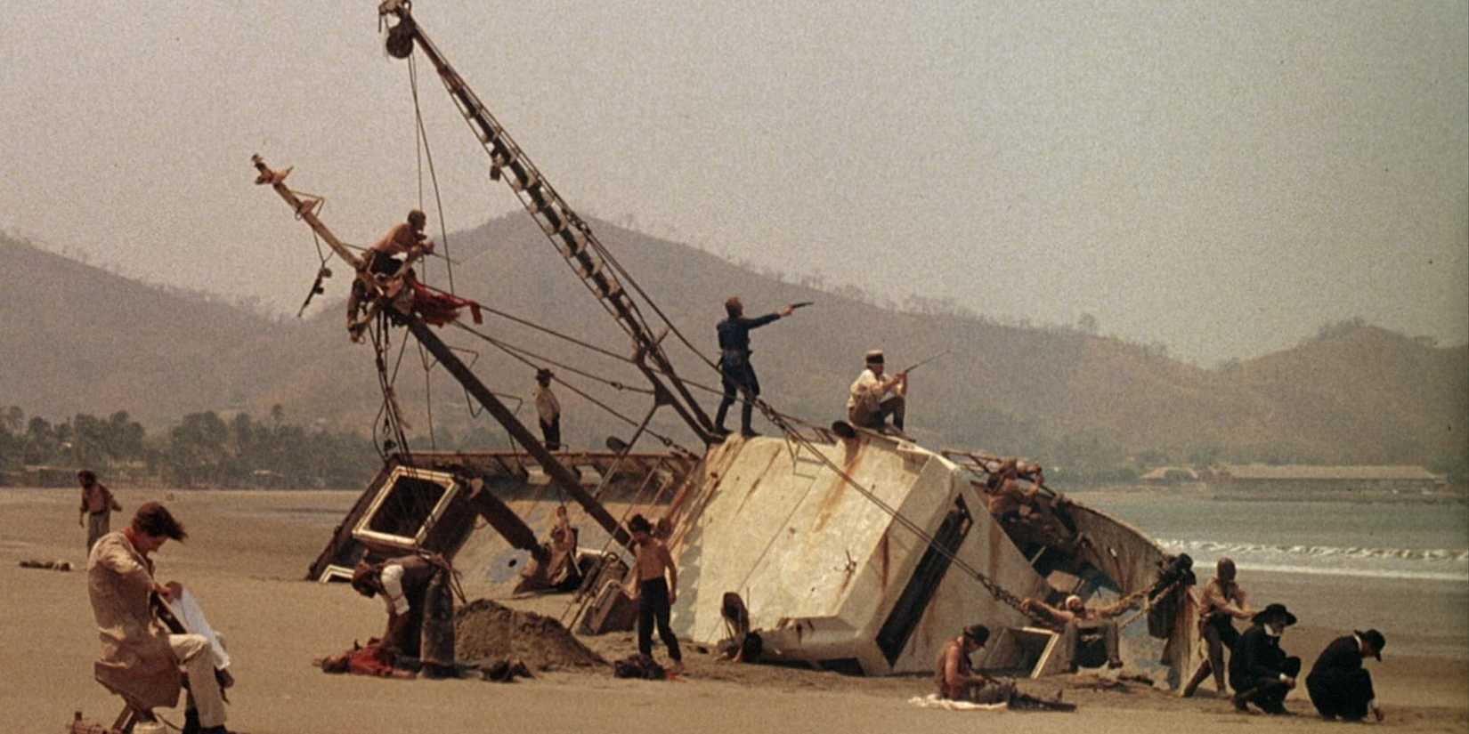 Walker's crew stands among their wrecked ship on the shore in 'Walker'