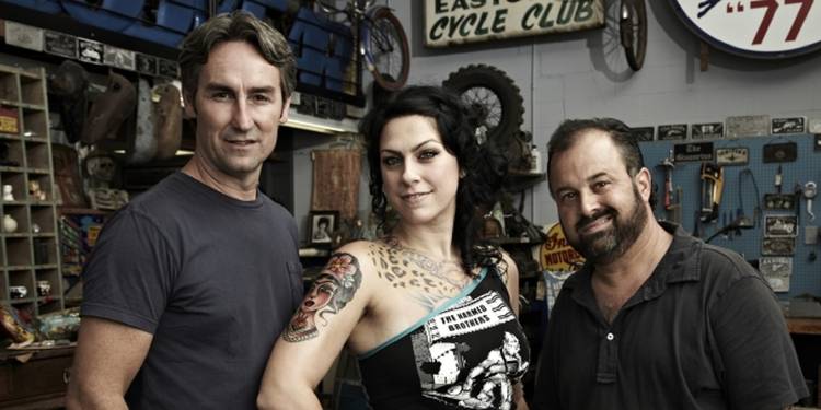 'American pickers' cast (Mike Wolfe, Danielle Colby, and Frank Fritz) standing together in an antique shop