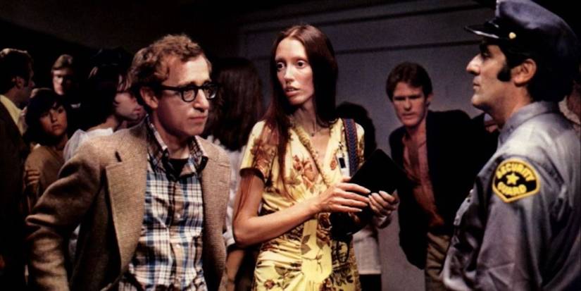 Alvy and Pam, played by Woody Allen and Shelley Duvall, stand in a crowd in front of a security guard in Annie Hall.