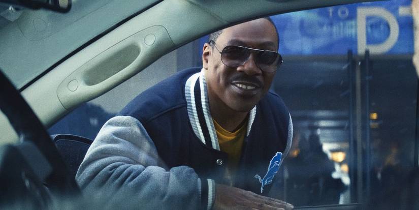 Axel Foley wearing sunglasses and leaning through a car window in Beverly Hills Cop 4.