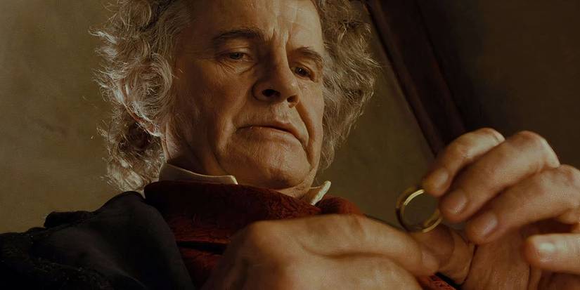 Still from The Fellowship of the Ring of Bilbo, played by actor Ian Holm, gazing at the One Ring he is holding.