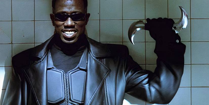 Wesley Snipes as Blade smiles and holds up a double-sided throwing weapon in Blade.