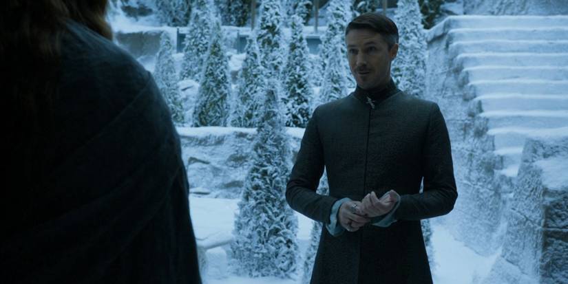 Lord "Littlefinger" Baelish (Aidan Gillen) stands in a snowy courtyard speaking with Sansa Stark in 'Game of Thrones' Season 4, Episode 7 "Mockingbird" (2014).
