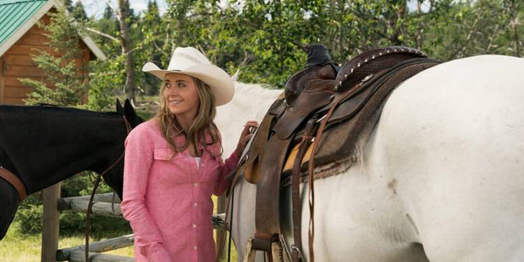 Amy Fleming (Amber Marshall) smiles with a horse in 'Heartland.'