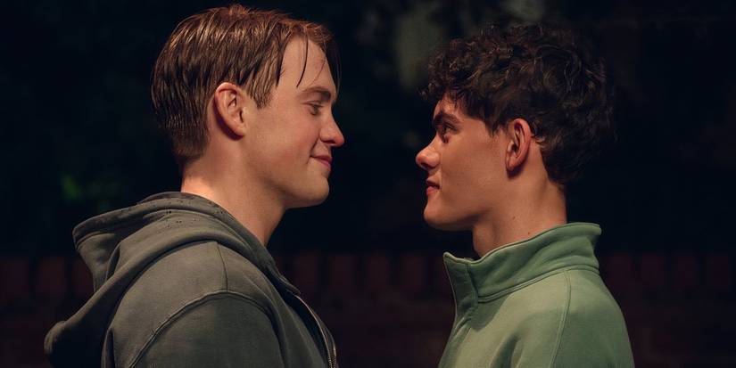 The two main characters stand and face each other and smile in Heartstopper.