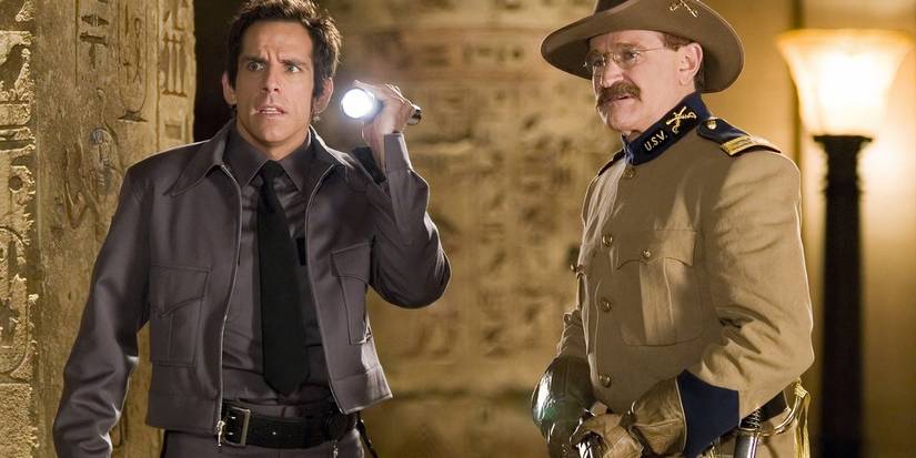 Ben Stiller as Larry shines a flashlight next to Robin Williams as Teddy Roosevelt in Night at the Museum.