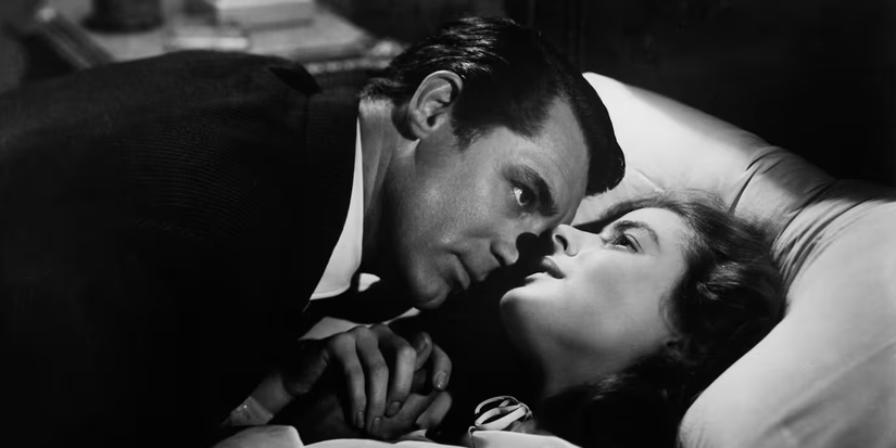 A man looks at a woman as she looks up, lying in bed together in Notorious.