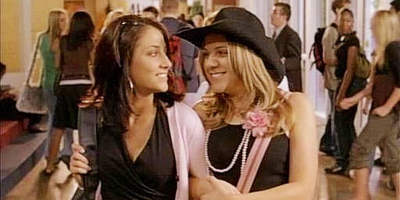 Paige and Alex with arms linked at school in Degrassi: The Next Generation DTNG