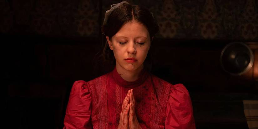 Pearl closing her eyes praying in 'Pearl' (2022).