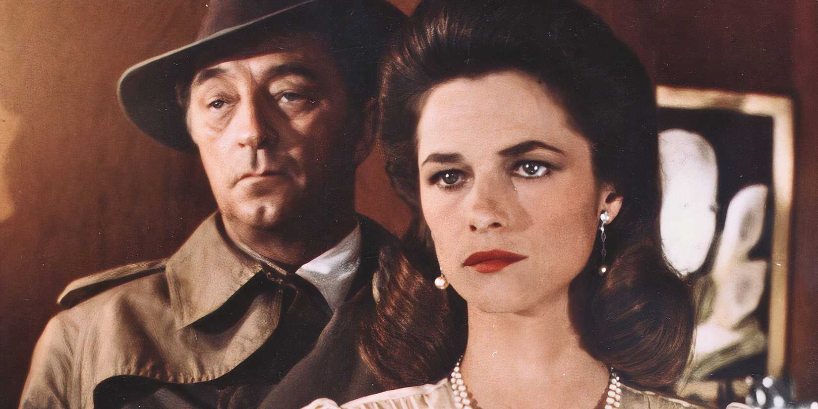 Robert Mitchum standing close behind Charlotte Rampling in Farewell, My Lovely (1975).