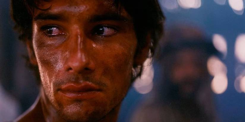 A dirty Rodrigo Santoro as Tonho looks over his shoulder solemnly in Behind the Sun