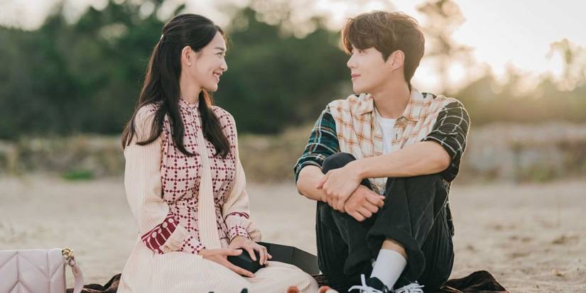 Shin Min-a and Seok Ho sitting on the sand in Hometown Cha Cha Cha.
