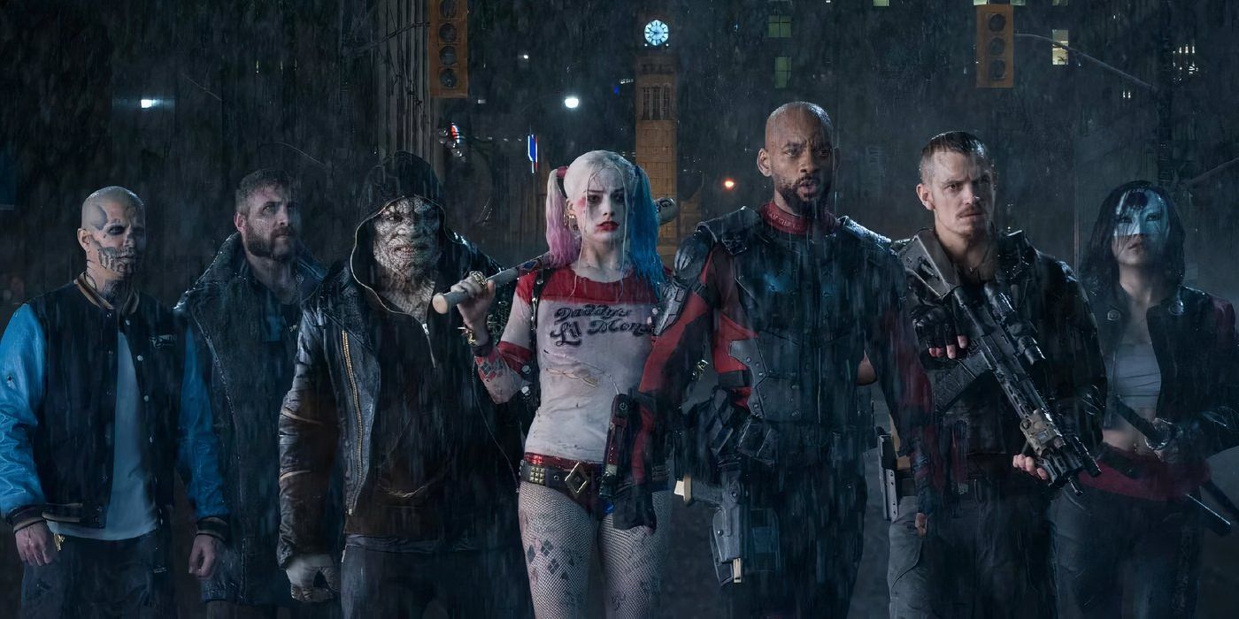The Suicide Squad stands in a line in the rain, armed and ready to fight.