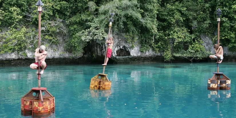Tom, Ian, and Katie hanging on buoys floating over a large body of water in the legendary final immunity challenge of Survivor: Palau