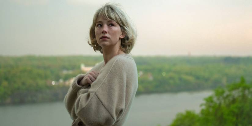 Haley Bennett as Hunter looking over her shoulder outside near a river in Swallow