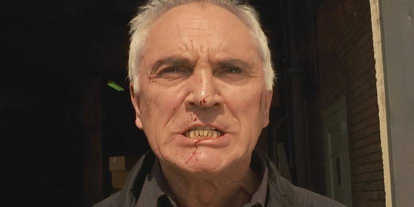A close-up of Terence Stamp grimacing with blood on his face in The Limey