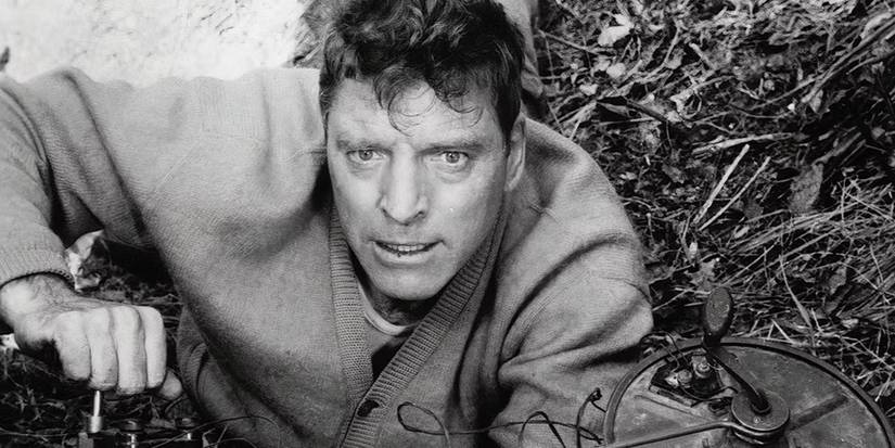 Burt Lancaster as Paul Labiche crouching in the woods in The Train (1964)