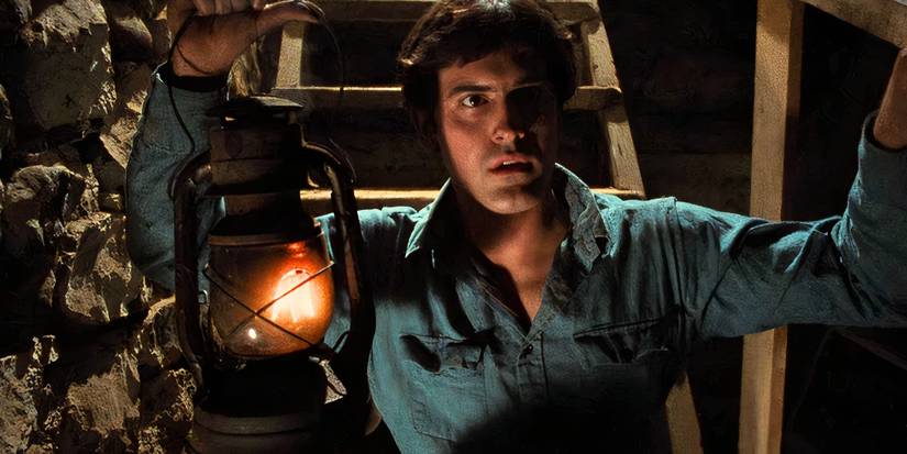 Ash holds a lantern in a dark cellar in The Evil Dead.