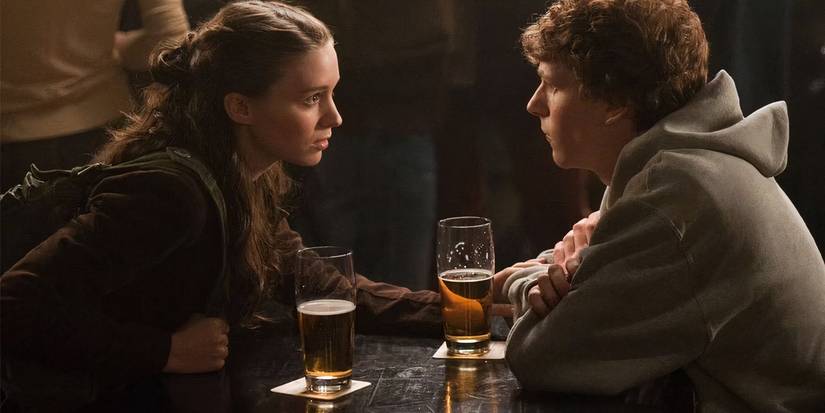 Rooney Mara as Erica (left) and Jesse Eisenberg as Mark (right) talk over beers in The Social Network.