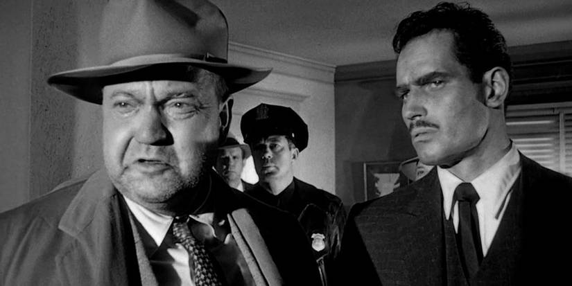Orson Welles as Hank Quinlan and Charlton Heston as Ramon Miguel Vargas in a crowded room in Touch of Evil.