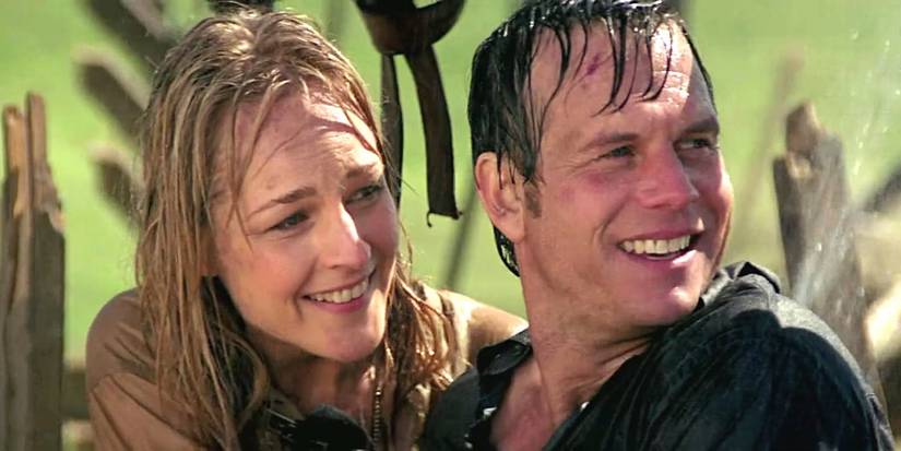 A rain-soaked Jo (Helen Hunt) and Bill Harding (Bill Paxton) smiling and looking offscreen to the right in Twister