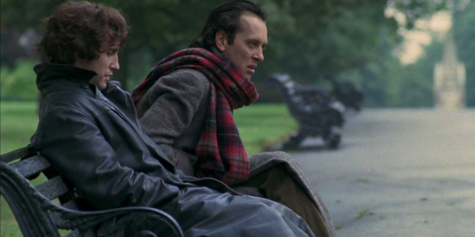 Withnail (Richard E. Grant) and Marwood (Paul McGann) sitting on a park bench in Withnail and I 