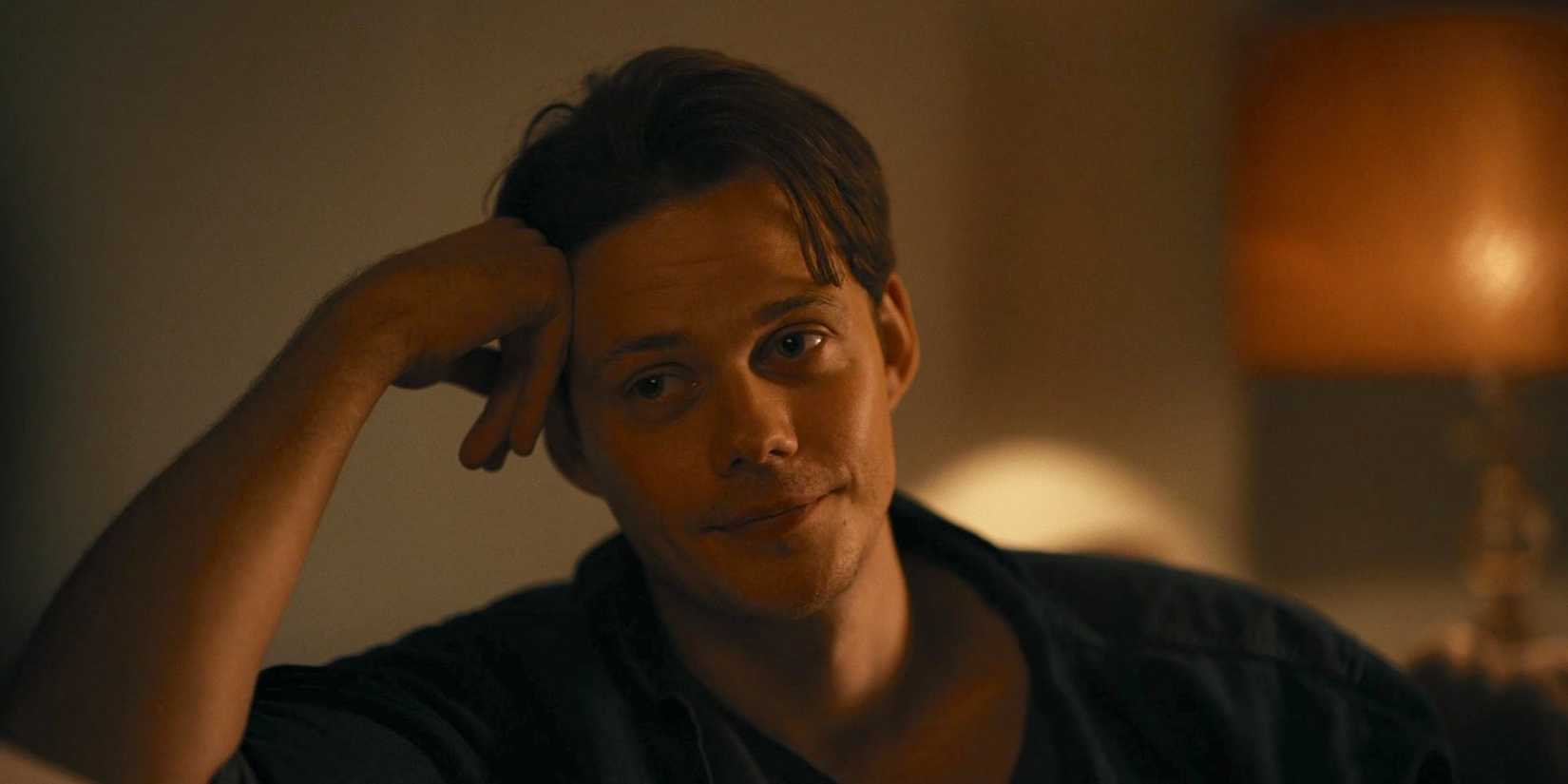 Keith (Bill Skarsgård) apoiando a cabeça na mão enquanto olhava para a direita em 'Bárbaro'