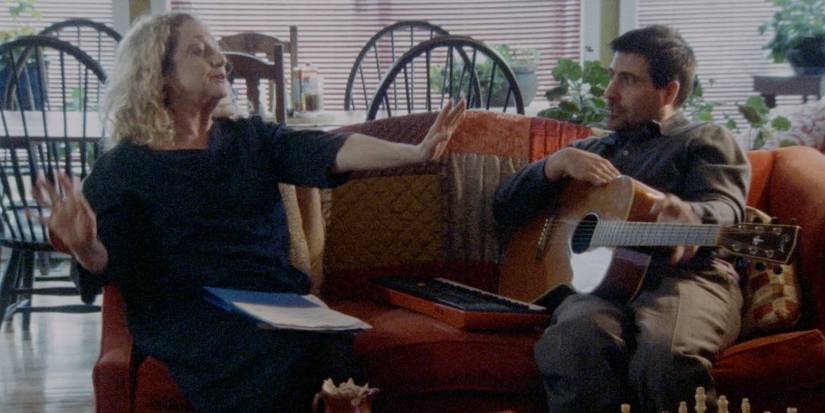 Jason Schwartzman and Carol Kane sit on a couch in Between the Temples.