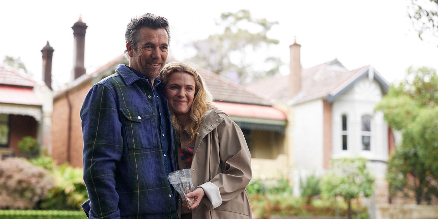 Patrick Brammall, and Harriet Dyer hug on the front lawn in 'Colin from Accounts'.