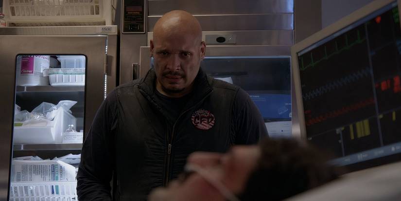 Joe Miñoso as Joe Cruz looking at Yuri Sardarov as Otis Zvonecek lying in a hospital bed in Chicago Fire.