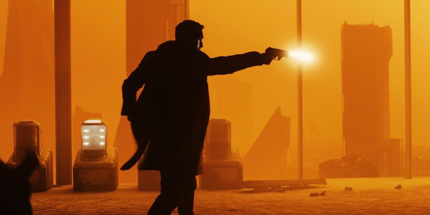 Ryan Gosling as the character Agent K. firing a gun in the film Blade Runner 2049 (2017).