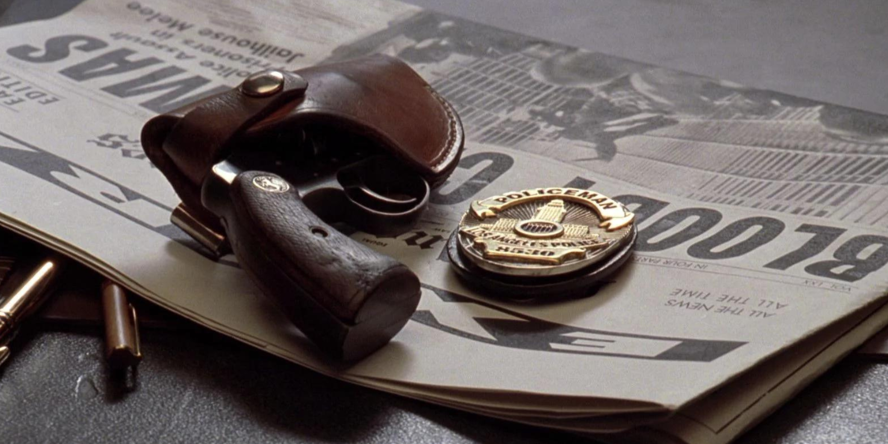 A detectives pistol sitting upon a newspaper reading 'bloody christmas' in the film L.A. Confidential.