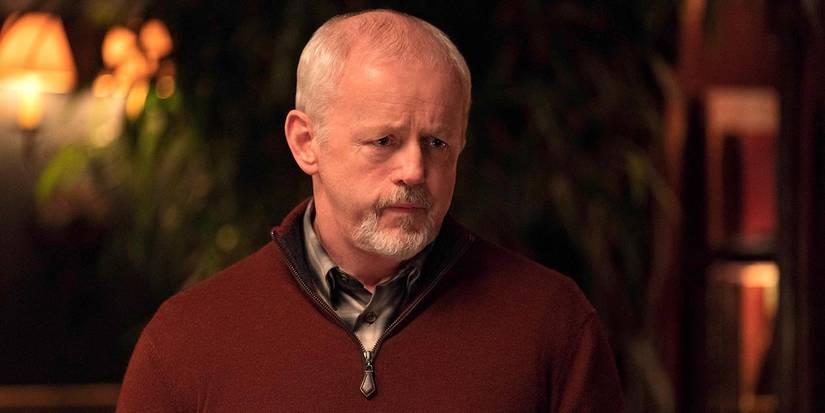 David Morse in a red sweater looking sullen in a scene from The Last Thing He Told Me