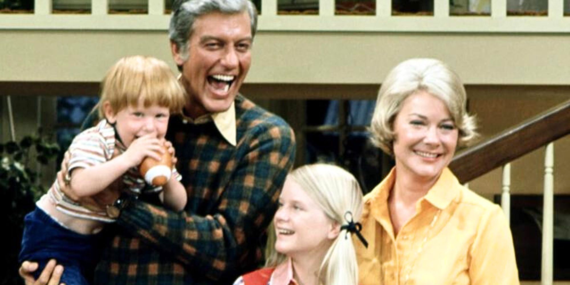 Dick Van Dyke holding a toddler while standing with Hope Lange and Angela Powell in The New Dick Van Dyke Show