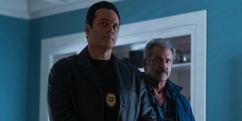 Mel Gibson and Vince Vaughn stand together with police badges on in Dragged Across Concrete.