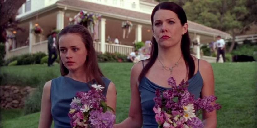 Gilmore Girls Lorelai and Rory standing with flowers- Lauren Graham and Alexis Bledel.
