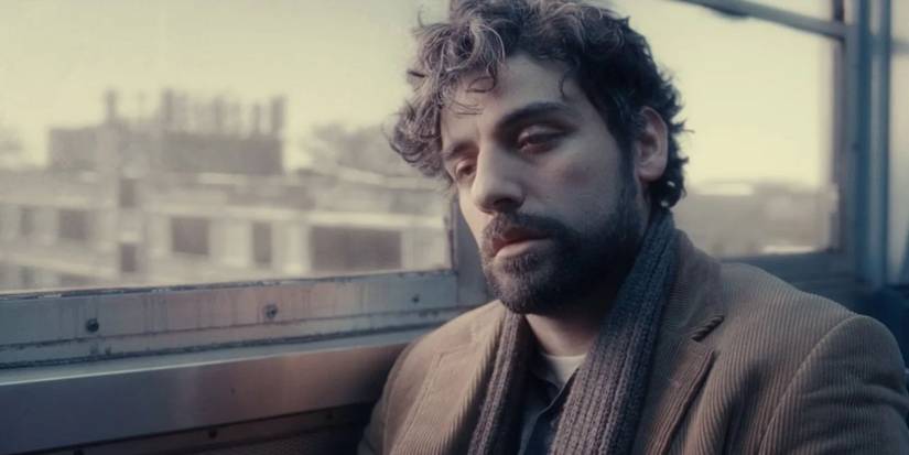 Oscar Isaac as Llewyn Davis looking tired on a train in Inside Llewyn Davis.