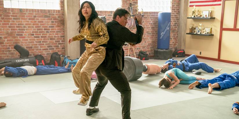 Awkwafina, havada bir silah kaldırırken John Cena'nın sırtına bağlandı