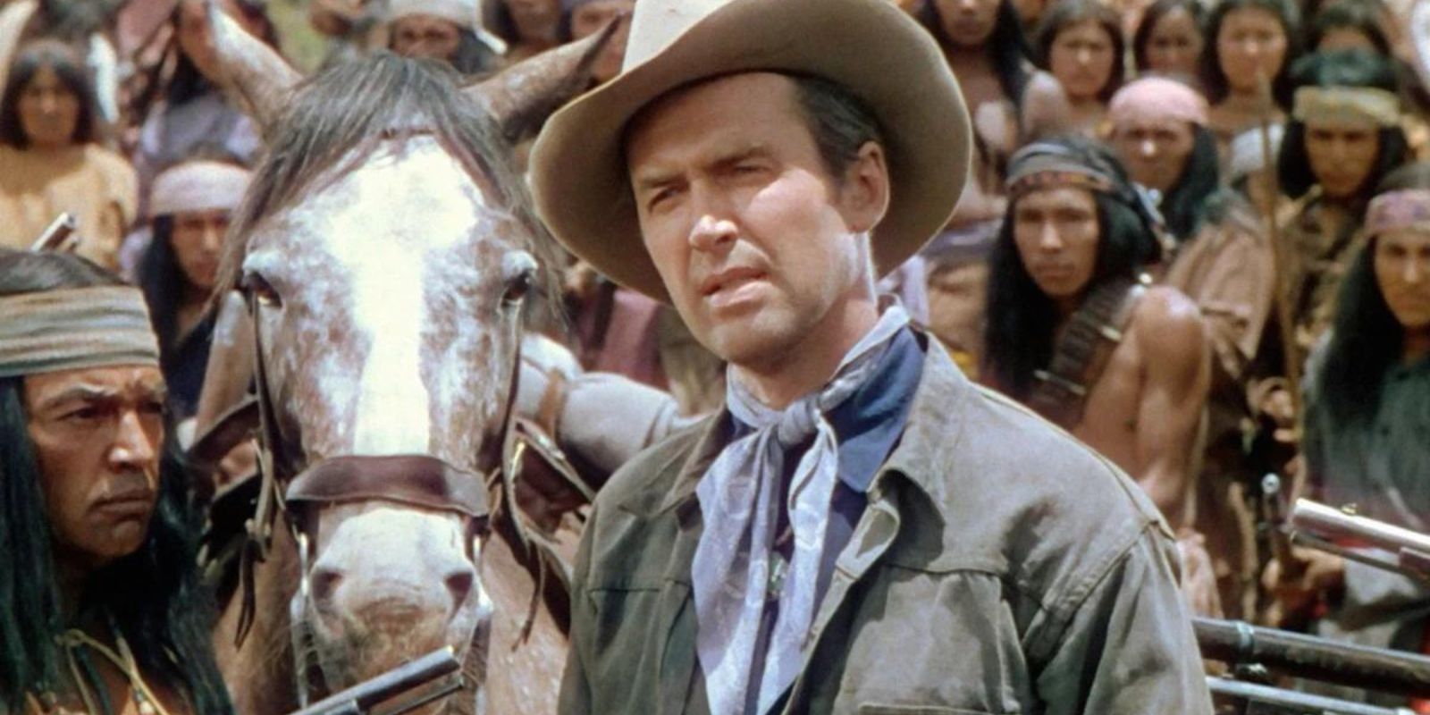 Tom Jeffords (James Stewart) standing next to a horse talking to someone in front of him in 'Broken Arrow.'