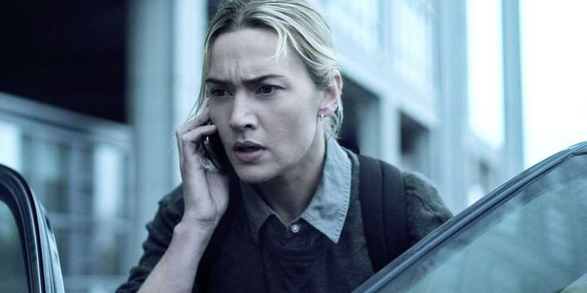Kate Winslet as Erin Mears, looking concerned on a phone about to get into a car in Contagion.