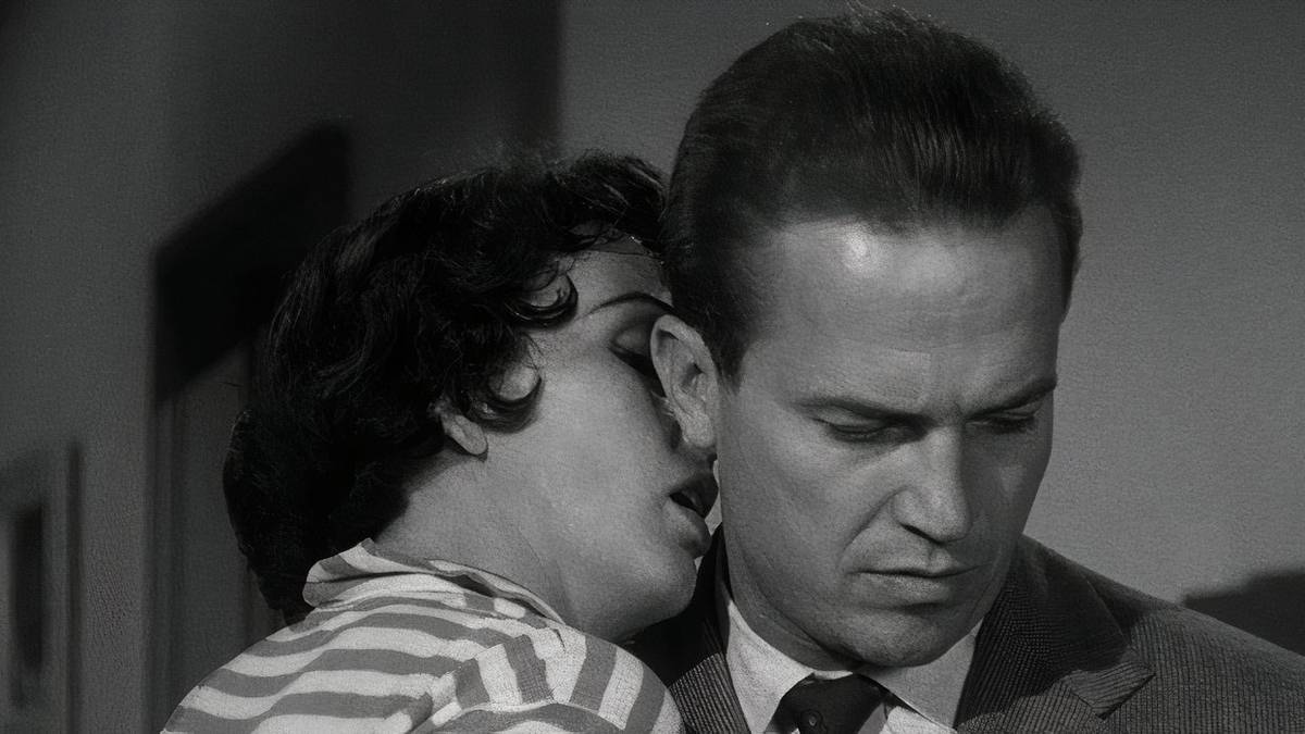 A woman kissing a man on the neck in 'Kiss Me Deadly'