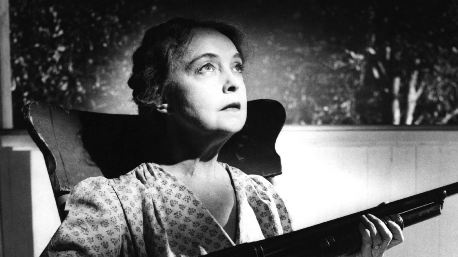 Lillian Gish as Rachel Cooper holding a rifle in The Night of the Hunter (1955)
