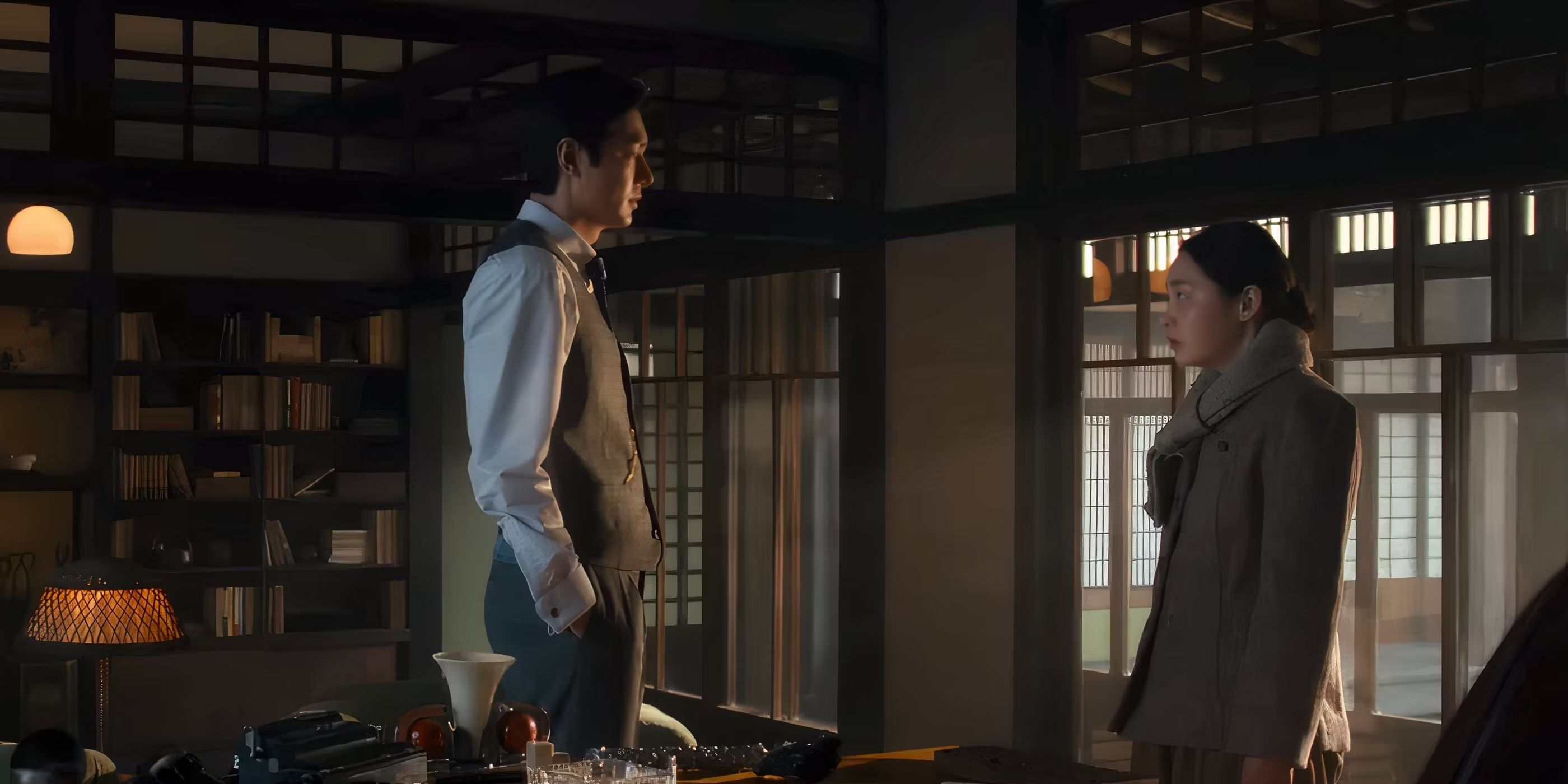 Hansu stands next to Sunja in a home library in a scene from Season 2, Episode 1 of 'Pachinko.'