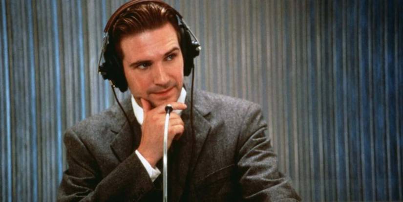 Ralph Fiennes listening to a question with vintage headphones in Quiz Show.