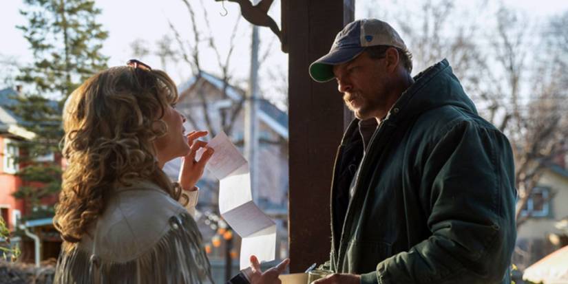 Hilary Swank and Alan Ritchson as shannon and Ed standing outside in a white jacket and sweatshirt in 'Ordinary Angels'