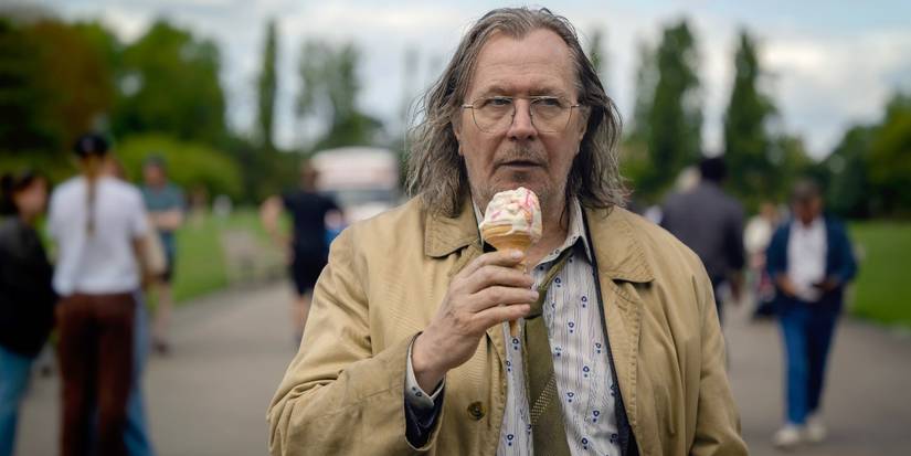 Gary Oldman eating an ice cream cone in a park in Slow Horses Season 3