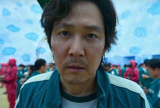 Gi-hun (Lee Jung-jae) stares at the camera in defeat in Squid Game.