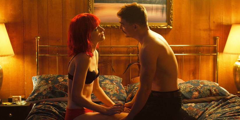 Kyle Gallner kneels on a bed in front of Willa Fitzgerald sitting cross-legged in a motel room