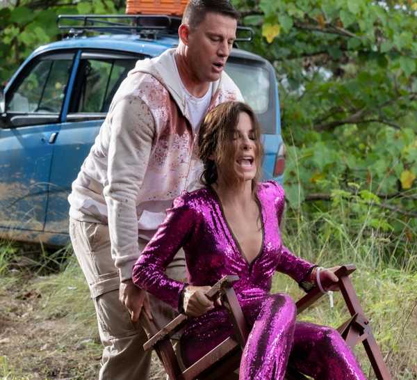 Channing Tatum's Alan pushing Sandra Bullock's Loretta in a chair in the jungle in The Lost City